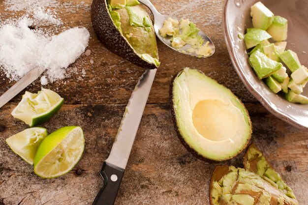 Hochwinkelansicht von Messer und halbiertem Avocado auf einem Holztisch