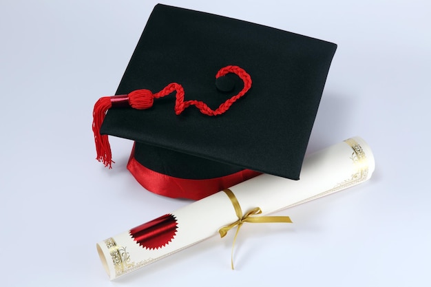 Hochwinkelansicht von Mörtelplatten und Diplom auf weißem Hintergrund