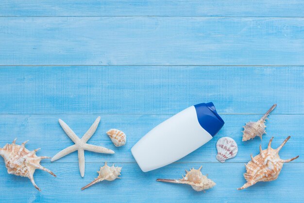 Foto hochwinkelansicht von muscheln und flasche auf blauem tisch