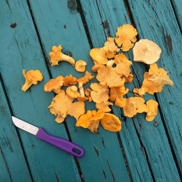 Foto hochwinkelansicht von pilzen und einem messer auf einem holztisch