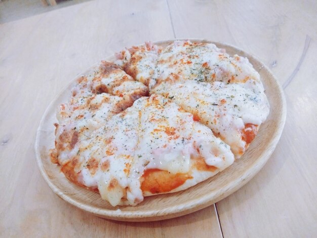 Hochwinkelansicht von Pizza auf einem Teller auf dem Tisch