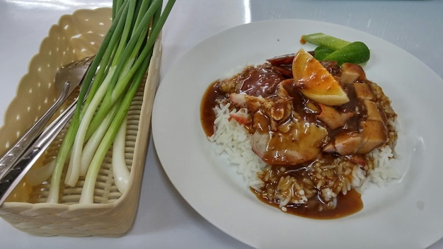 Foto hochwinkelansicht von reis mit curry, das auf einem teller auf dem tisch serviert wird