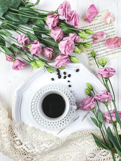 Hochwinkelansicht von rosa Blumenkaffee und Donut auf dem Tisch