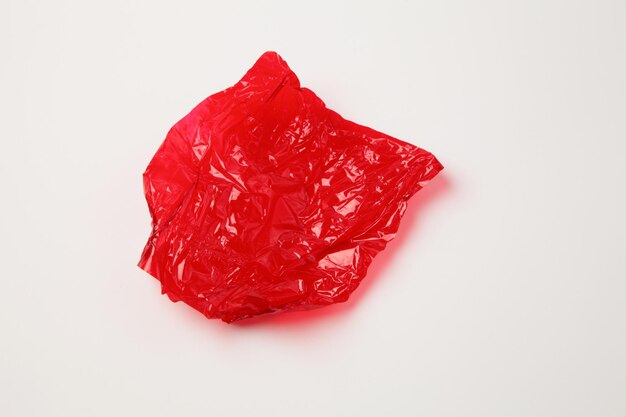 Foto hochwinkelansicht von roten kunststoffpapieren vor weißem hintergrund