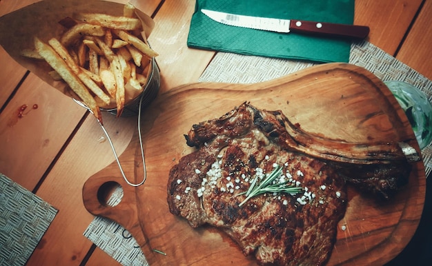 Foto hochwinkelansicht von steak und pommes frites auf dem tisch