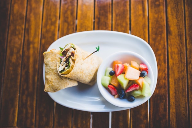 Hochwinkelansicht von Tacos und Früchten auf dem Tisch