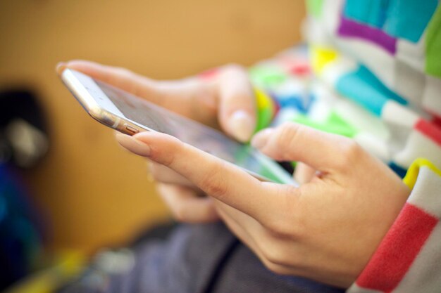 Hochwinkelansicht von weiblichen Händen mit Handy