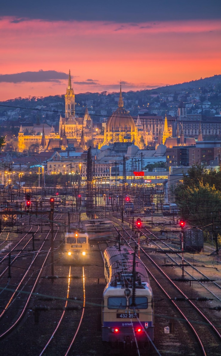 Foto hochwinkelansicht von zügen mit stadtbild beim sonnenuntergang