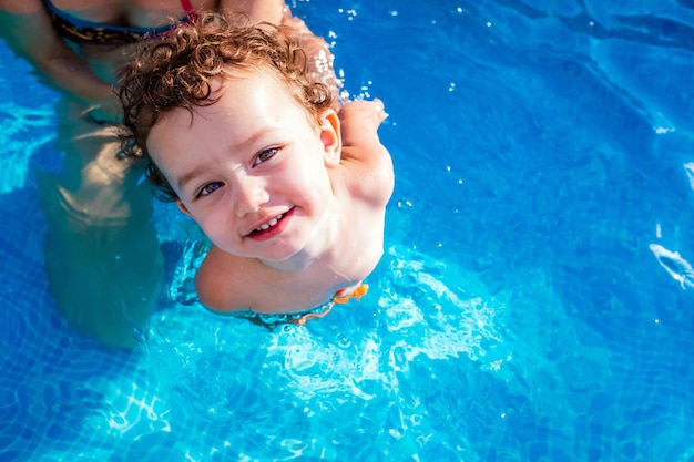 Hochwinkelporträt eines hemdlosen Babys, das im Schwimmbad steht