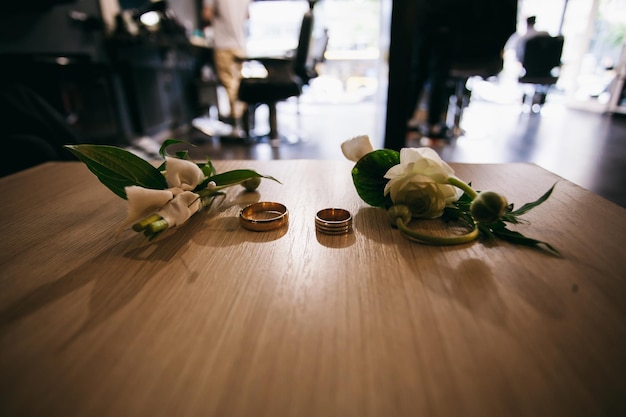 Hochzeit Anstecker und Eheringe auf dem Tisch, Weitwinkelfoto, Nahaufnahme