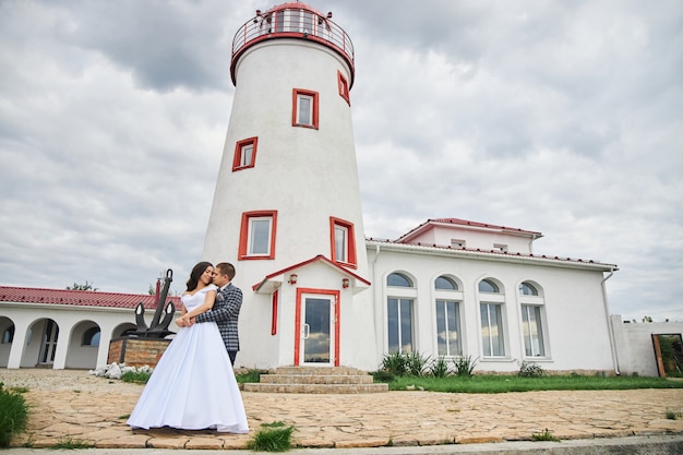 Hochzeit eines verliebten Paares in der Natur am Leuchtturm.