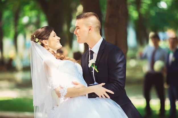 Hochzeit, gerade verheiratetes Paar küssen in einem Park, Hochzeitskonzept.