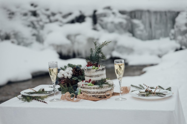 Hochzeit im Winter. Hochzeitsdekor, Kuchen, Gläser, Champagner, Teller.