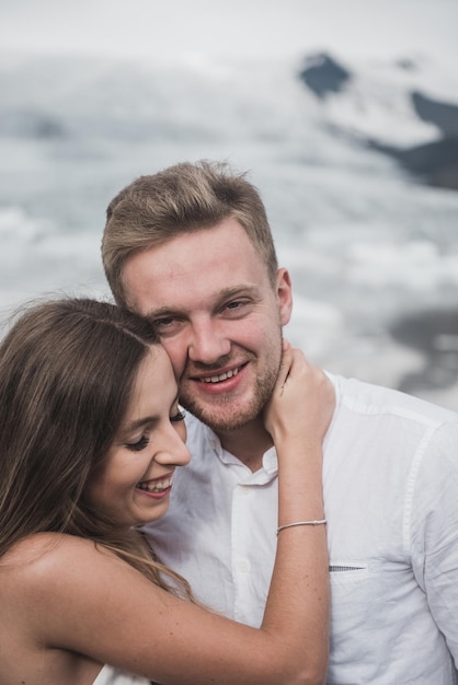 Hochzeit in Island. Ein Mann und ein Mädchen in einem weißen Kleid umarmen sich, während sie auf einem blauen Eis stehen