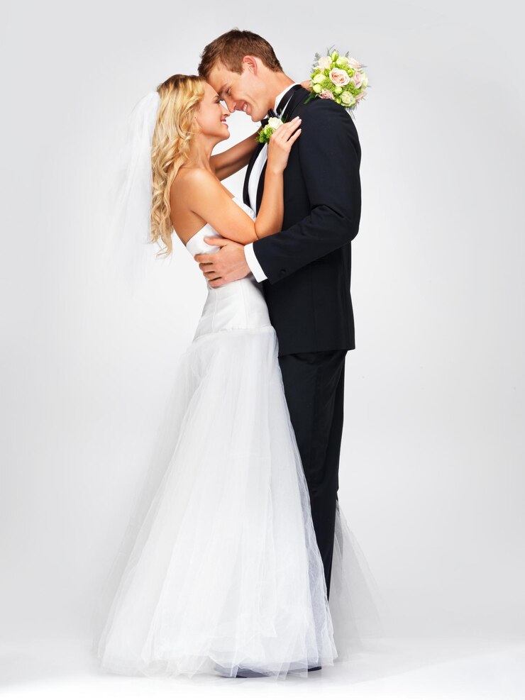 Foto hochzeit lächeln paar umarmung und weißer hintergrund studioportrait glücklich und verliebt mann und schöne junge frau ehe blumen blumenstrauß in der hand der braut und lehnen sich an, um das fröhliche gesicht des mannes zu küssen