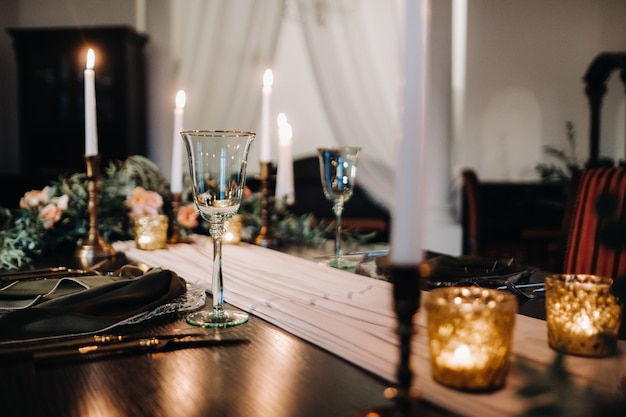 Hochzeit Tischdekoration mit Blumen auf dem Tisch im Schloss, Tischdekoration zum Abendessen bei Kerzenschein. Abendessen mit Kerzen.