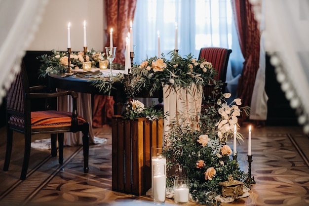 Hochzeit Tischdekoration mit Blumen auf dem Tisch im Schloss, Tischdekoration zum Abendessen bei Kerzenschein. Abendessen mit Kerzen.