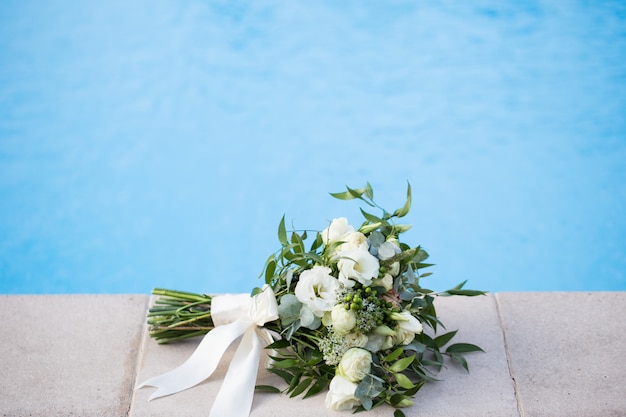 Hochzeits-Brautstrauß auf einer blauen Hintergrundnahaufnahme.