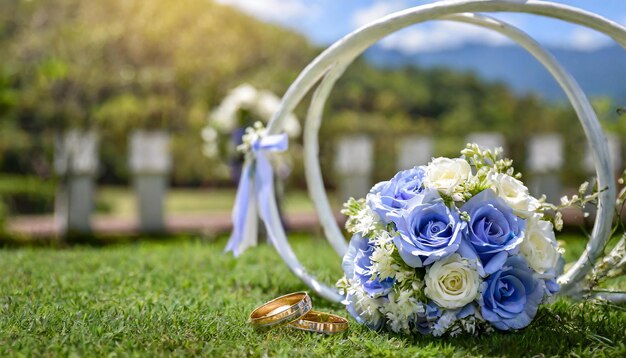 Foto hochzeits-natur-hintergrund mit blauen rosen, goldringen und weißen dekorationen