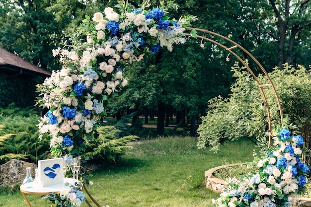 Hochzeitsbänke mit Gästen und Blumenbogen für die Zeremonie im Freien