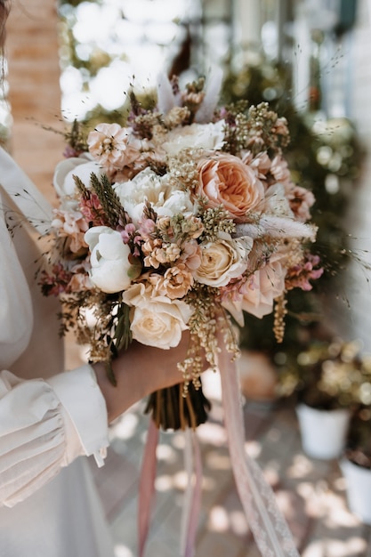 Hochzeitsblumen in der Hand einer Braut. Blumenstrauß, der Ehe und Liebe darstellt.