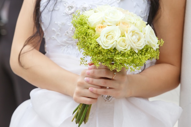 Hochzeitsblumenstrauß in den Händen der Braut