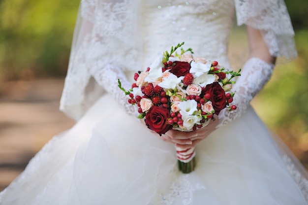 Hochzeitsblumenstrauß von Rosen in den Händen der Braut