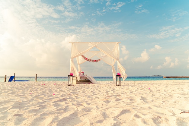 Hochzeitsbogen am Strand mit tropischen Malediven Resort und Meer