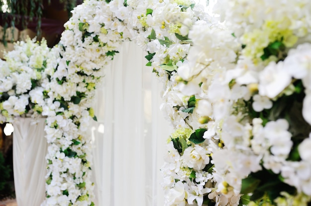 Hochzeitsbogen von weißen Orchideen und von Rosen