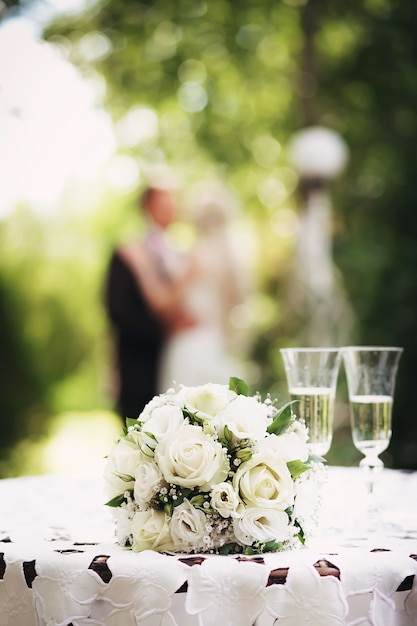 Hochzeitsbrautstrauß mit weißen Rosen auf dem Tisch im Garten