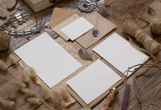 Hochzeitsbriefpapierset mit Umschlag auf einem Holztisch mit böhmischer Dekoration herum