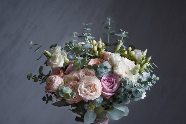 Hochzeitsbuequet mit weißen Rosen auf grauem Hintergrund. Nahansicht