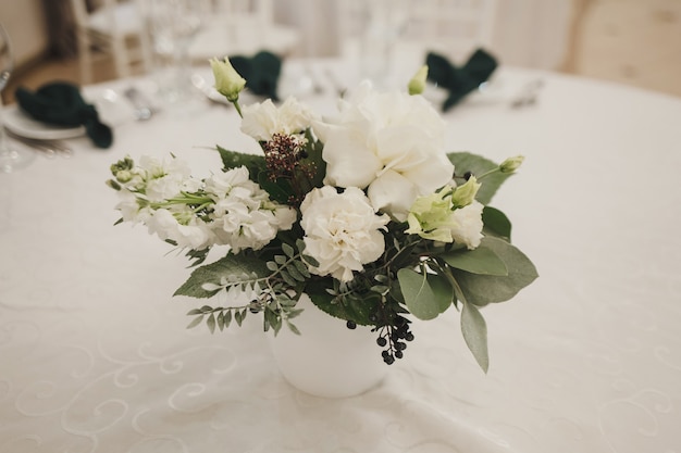 Hochzeitsdeko auf dem Tisch. Ein Strauß frischer Blumen.
