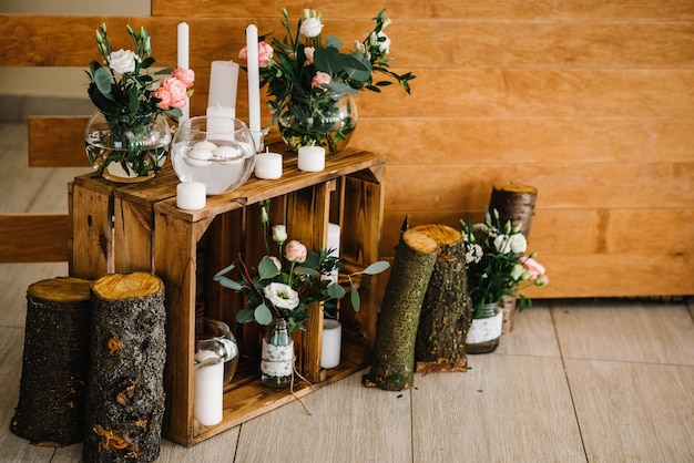 Hochzeitsdekoration aus Holz mit Kerzen Der Holzbogen für die Zeremonie ist mit Blumen und Grün geschmückt. Originelle Blumendekoration für die Hochzeit Empfang