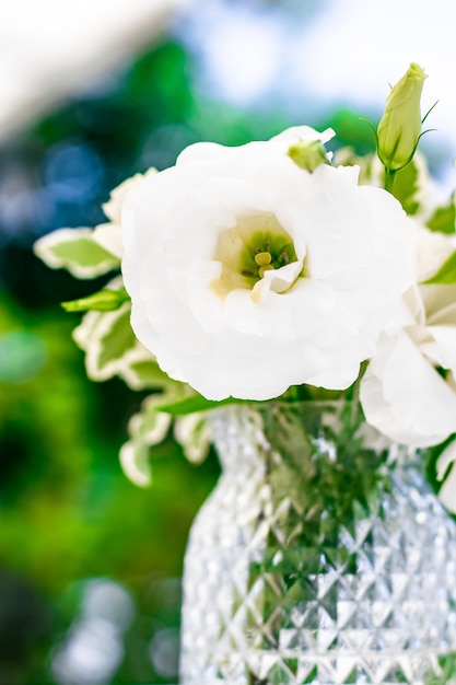 Hochzeitsdekoration Tischdekor und floraler Schönheitsstrauß aus weißen Rosen im Luxusrestaurant schön...