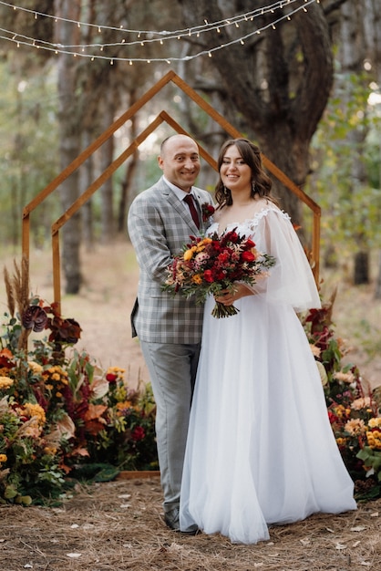 Hochzeitsessen eines frisch vermählten Paares im Herbstwald vor dem Hintergrund der Hochzeitszeremonie