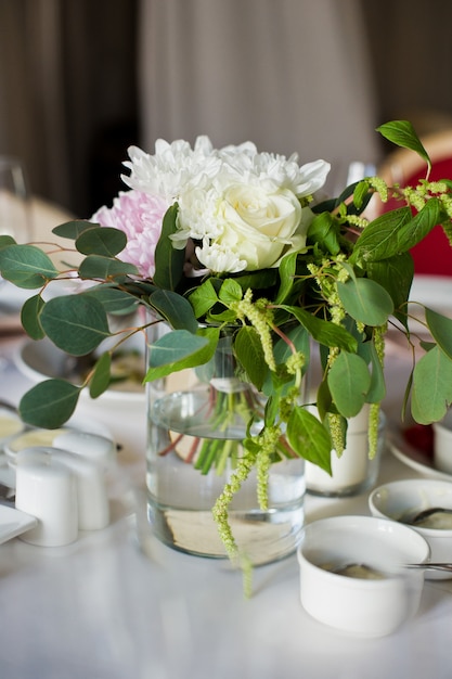 Foto hochzeitsessen im restaurant, tische mit rosenvasen dekoriert.