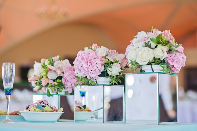 Hochzeitsessen im Restaurant, Tische mit Rosenvasen dekoriert.