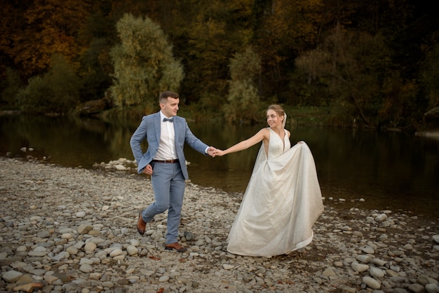 Hochzeitsfoto-Sitzung der Braut und des Bräutigams in den Bergen. Fotoshooting bei Sonnenuntergang.