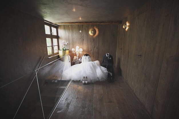 Foto hochzeitskleid und anzug auf dem sitz zu hause