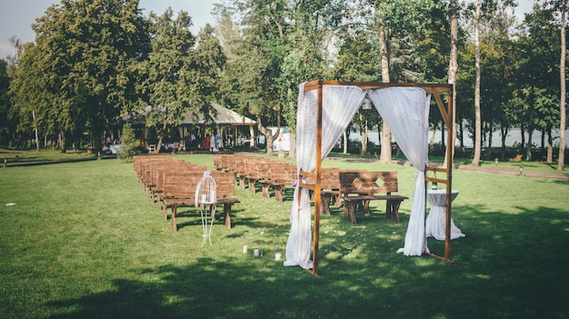 Hochzeitskonzept mit einem Hochzeitsbogen, der auf einem grünen Rasen liegt