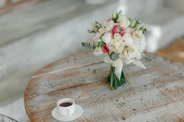 HochzeitsmorgenHolzweinleseweißer Couchtisch und Hochzeitsblumenstrauß