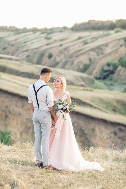 Hochzeitspaar auf der Natur im Sommertag. Braut und Bräutigam umarmen sich bei der Hochzeit.