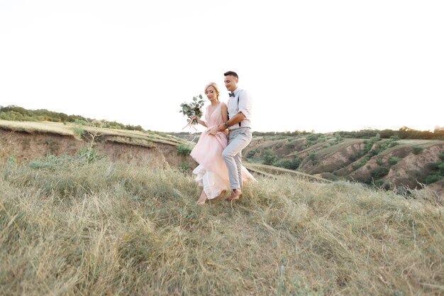 Hochzeitspaar auf der Natur im Sommertag. die Braut und der Bräutigam gehen