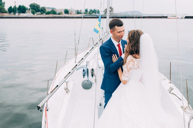 Hochzeitspaar auf der yacht, liebhaber posieren auf der yacht