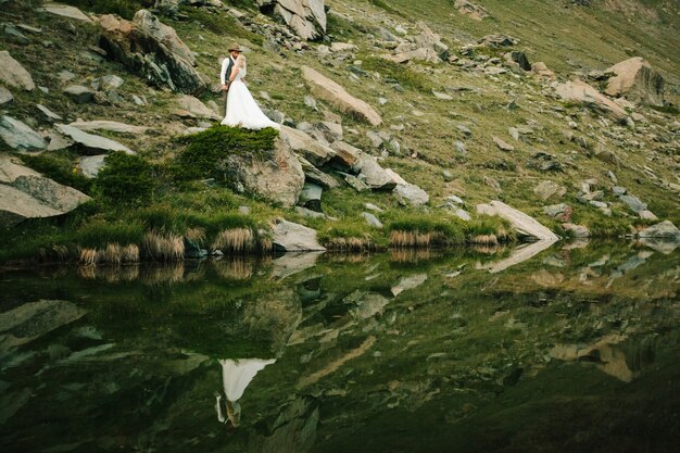 Hochzeitspaar in den Bergen neben einem See