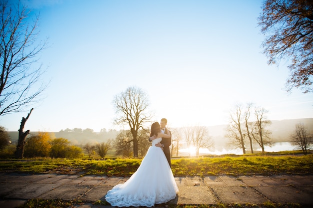 Hochzeitspaar in einem Wald in den Bergen bei Sonnenuntergang