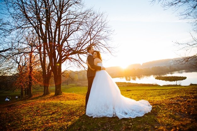 Hochzeitspaar in einem Wald in den Bergen bei Sonnenuntergang