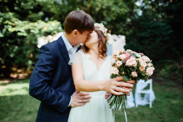 Hochzeitspaar küsst bei einer Zeremonie im Freien