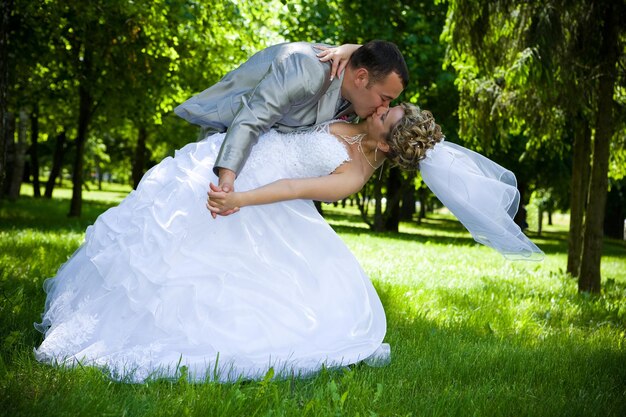 Foto hochzeitspaar küsst sich im park